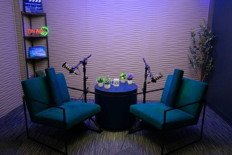 Recording table with microphones and chairs at Downtown Tucson Podcast Studio.